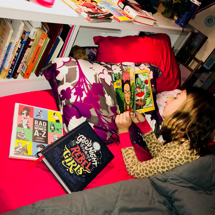 image of a child reading a book in bed