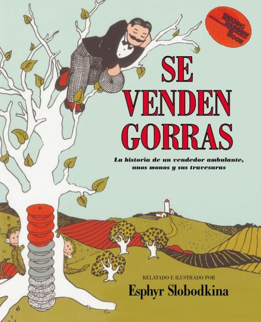Book cover of Se Venden Gorras, La Historia de un Vendedor Ambulante, unos monos y sus travesuras with an illustration of a man in a tree with caps stacked next to the tree.