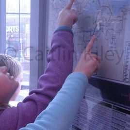 children pointing on map