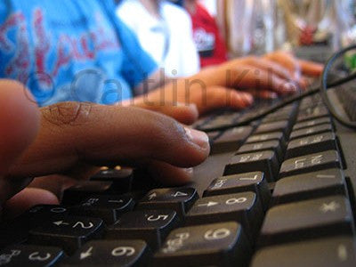 close up image of child's fingers on keyboard