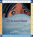 Book cover of En la Oscuridad with an illustration of a child hiding under the covers.